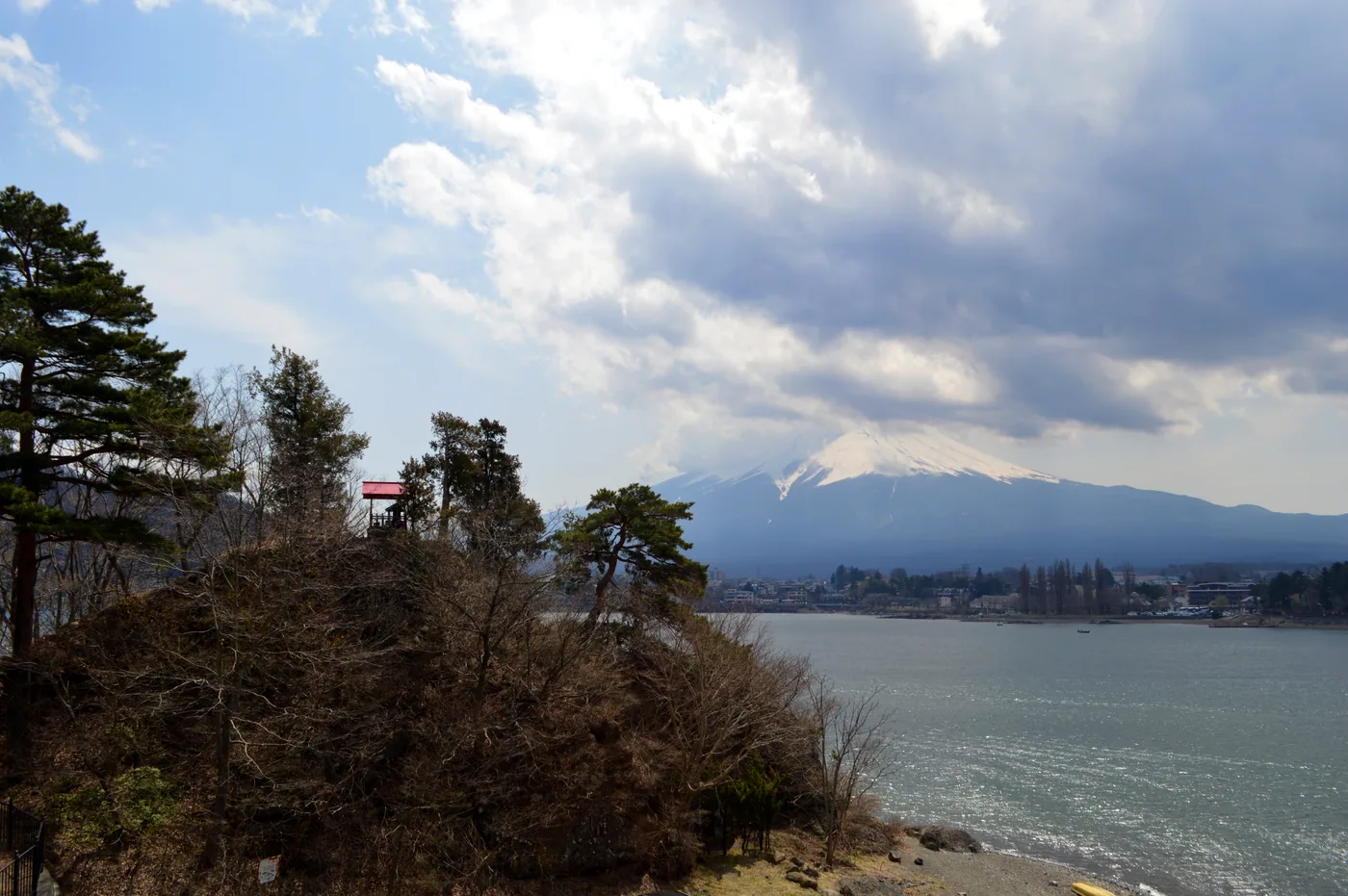 Clouds partly cover Mount Fuji above Lake Kawaguchi, viewed past Ubuyagasaki.